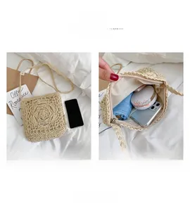 Detail view of the spacious interior of a beige woven straw crossbody bag for daily items
