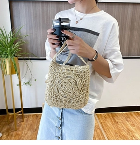 Detailed macro view of the handcrafted mandala floral weave on a beige straw bag
