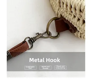 Detail of vintage bronze hardware hook and reinforced leather trim on woven beach bag