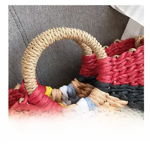 Macro shot of colorful woven texture and thick round handle on a bohemian straw handbag