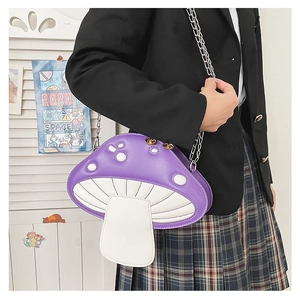 Detail view of a purple mushroom crossbody bag with chain strap on a female model