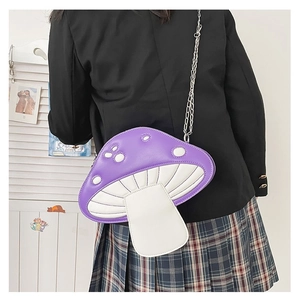 Detailed view of mushroom crossbody bag with silver chain strap on model's shoulder