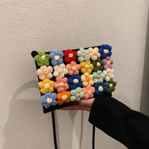 Handcrafted black knit crossbody bag with colorful 3D crochet flowers for women