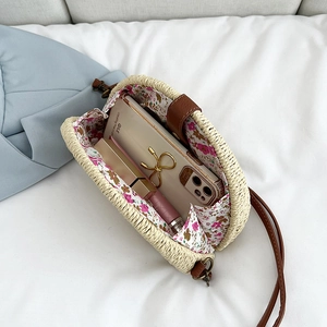 Handwoven straw crossbody bag with floral lining and leather strap for beach vacations
