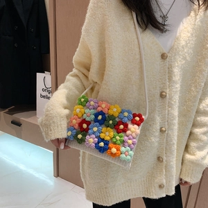 Handmade crochet crossbody bag with colorful knitted flowers on cream white strap