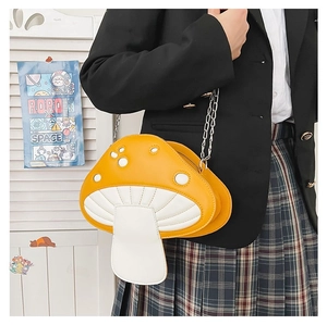 Close-up of yellow mushroom crossbody bag with silver chain on model in black blazer