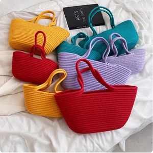 Assorted colorful cotton rope woven tote bags in various sizes displayed on white fabric
