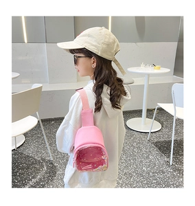 Pink transparent PVC kids chest bag with colorful sequins shown in a lifestyle cafe setting