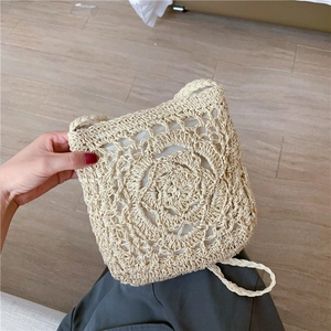 Handmade straw crossbody bag with floral crochet pattern for beach and summer vacations