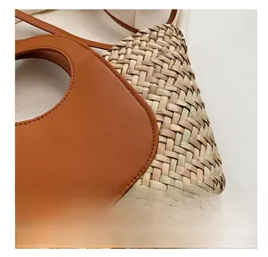Detail view of woven straw bucket bag with premium brown leather stitching and fine seams