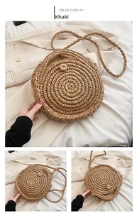 Detail of khaki round straw bag showing intricate spiral weave and woven buckle closure