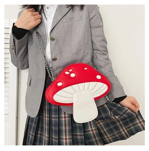 Crossbody bag shaped like a red mushroom with white dots and a silver chain strap