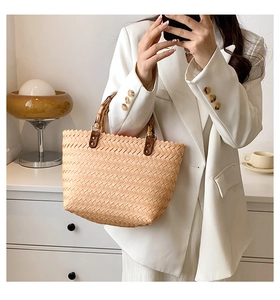 Detailed view of bamboo handle and straw texture on summer beach tote bag