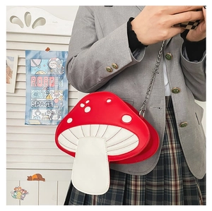 Detail of red and white mushroom crossbody bag with quilted pattern and metal chain