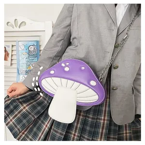 Detail shot of a purple mushroom crossbody bag with white dots and metal chain strap