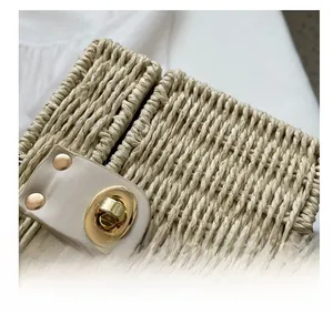 Detailed close-up of woven straw bag with premium metal turn-lock and cream leather trim