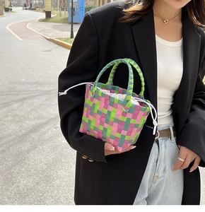 Dettaglio mini borsa a cesto intrecciata a mano verde e rosa con fodera a coulisse