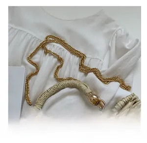 Detailed macro view showing the woven texture and golden chain strap of the straw beach bag