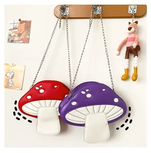 Detail of red and purple mushroom shaped crossbody bags with silver chain straps