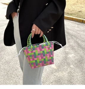 Dettaglio borsa a mano intrecciata a scacchi rosa e verde con coulisse bianca