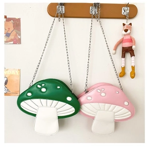 Detail of green and pink mushroom crossbody bags with quilted caps and metal chains