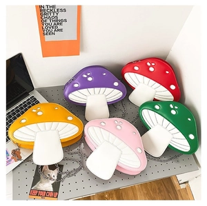 Detailed view of colorful mushroom-shaped crossbody bags with metal chains and white dots