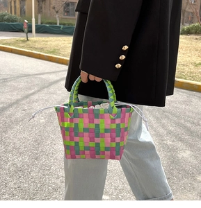 Dettaglio di una borsa a cesta intrecciata a mano colorata con fodera a coulisse bianca