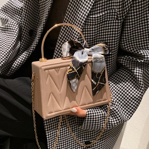 Quilted beige box bag with gold handle, decorative silk scarf and chain shoulder strap