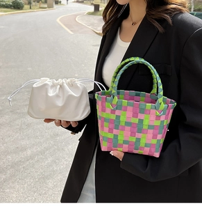 Dettaglio di borsa tote intrecciata colorata con motivo a scacchi rosa e verde e sacca interna