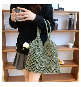 Close-up of green woven mesh beach bag with thick spiral texture handles and knot detail