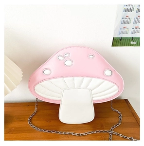 Detail of pink and white mushroom shaped shoulder bag with golden metal chain strap