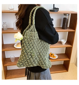 Detail of light green hollow woven tote bag with a white rose on a wooden shelf