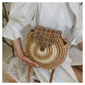 Detail of hand-woven circular straw bag with vintage cork lid and leather strap