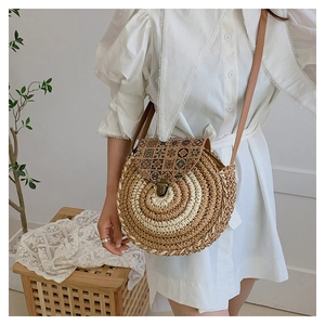 Detail view of round straw bag with vintage totem print and bronze metal clasp