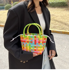 Dettaglio della borsa shopper intrecciata arcobaleno con manico verde e fodera interna