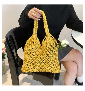 Detail of a bright yellow hand-woven mesh beach tote bag with cotton rope handles