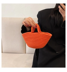 Detail of orange hand-woven cotton rope mini bag featuring sturdy cylindrical handles