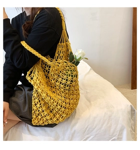 Detail of yellow hand-woven mesh beach bag with cotton rope texture and hollow design