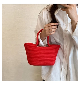 Detail of red hand-woven cotton rope tote bag with spiral texture for summer leisure