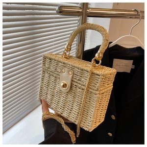 Detailed straw woven box bag featuring a gold chain strap and a metallic turn-lock closure