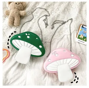 Detailed view of pink and green mushroom crossbody bags with silver chain on lace