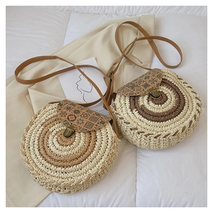 Detail of round straw crossbody bags with ethnic floral flap and retro metal lock