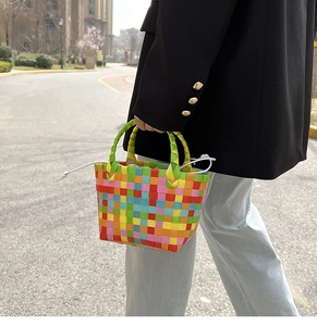 Dettaglio della borsa intrecciata colorata con manici verdi e coulisse bianca per l'estate