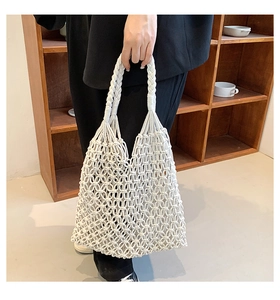 Detail of hand-woven macramé beach bag featuring intricate mesh knots and cotton handles