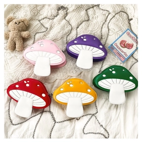 Flat lay of colorful mushroom-shaped crossbody bags with metal chains on lace background
