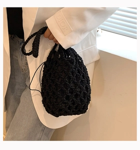 Primer plano de bolso saco de algodón tejido negro con forro de cordón y diseño calado