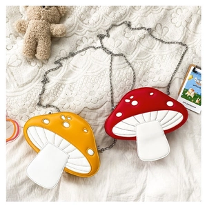 Detailed top view of red and yellow mushroom crossbody bags with silver chain straps