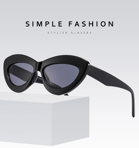 Detail of trendy black cat-eye sunglasses with thick frames on a display stand
