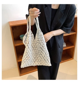 Detail of white macrame woven tote bag featuring diamond hollow mesh and spiral handles