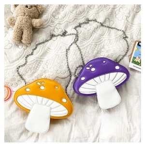 Detailed close-up of colorful mushroom-shaped crossbody bags with metal chains on lace
